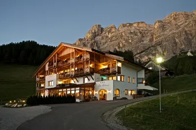 a restaurant with wooden tables and a bar at B&B - Ciasa Rü Blanch in San Cassiano