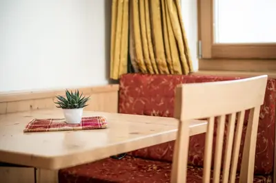 a kitchen and living room with wooden floors and windows at B&B - Ciasa Rü Blanch in San Cassiano
