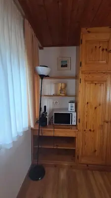 a lamp in a corner of a room with a microwave at Apartments Antares in Colfosco