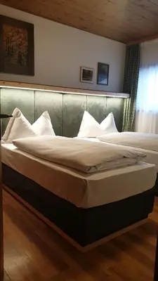 two beds in a bedroom with a headboard at Apartments Antares in Colfosco