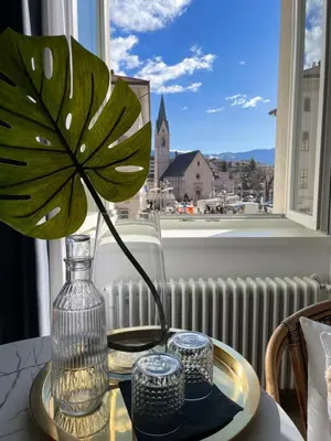 a flower in a vase on a table with a window at Al Palazzo in Cles