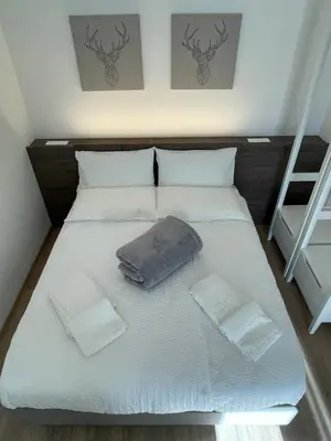 a bed with white sheets and two pillows on it at Al Palazzo in Cles