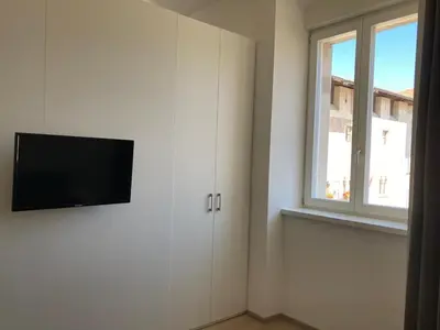 a room with a flat screen tv on a white wall at Al Palazzo in Cles