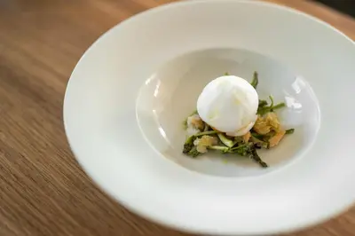 a white plate with an ice cream on top at Miramonti Boutique Hotel in Avelengo