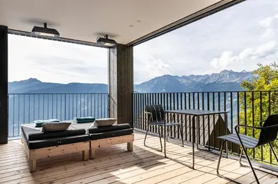 a bedroom with a bed and a large window at Miramonti Boutique Hotel in Avelengo
