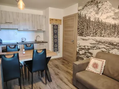 a kitchen and dining room with a table and chairs at Mountain Hut Veronza in Cavalese