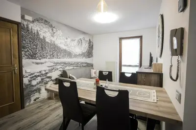 a dining room with a wooden table and chairs at Mountain Hut Veronza in Cavalese