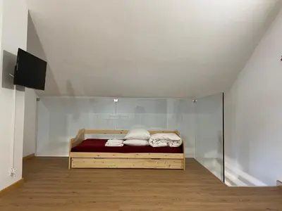 a bed in a room with a glass wall at Casa Eolo Falcade in Falcade