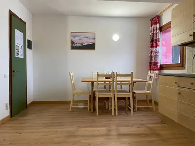 a kitchen and dining room with a table and chairs at Casa Eolo Falcade in Falcade