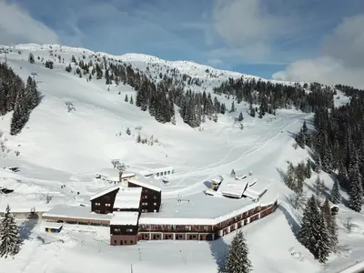 a ski lodge on a snow covered mountain with trees at Casa Eolo Falcade in Falcade