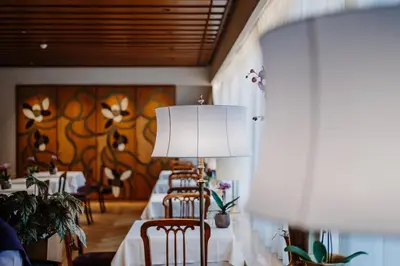 a row of tables in a restaurant with a lamp at Hotel Adria in Merano