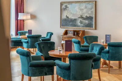 a meeting room with chairs and a table and a painting at Hotel Adria in Merano
