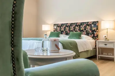 a hotel room with two beds and a table at Hotel Pienzenau Am Schlosspark in Merano