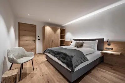 a bedroom with two beds and a large window at DILIA Chalets & Apartments in Mühlbach
