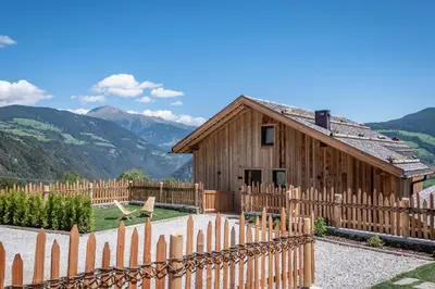 a bedroom with a large bed and a bath tub at DILIA Chalets & Apartments in Mühlbach