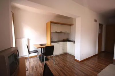 a kitchen with a table and chairs and a television at Residence Haus Ragen in Brunico