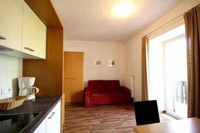 a kitchen with a red couch in a room at Residence Haus Ragen in Brunico