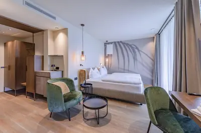 a hotel room with a bed and chairs and a table at VILLA NAJ in Termeno