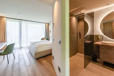 a hotel room with a bed and a bathroom at VILLA NAJ in Termeno