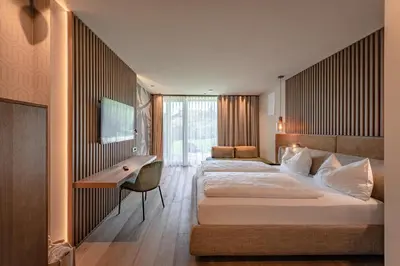 a hotel room with two beds and a desk at VILLA NAJ in Termeno