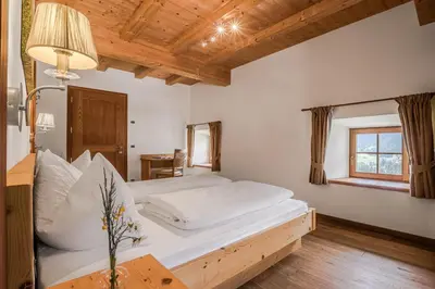a bedroom with a large white bed and a window at Lüch da Fusse in Badia