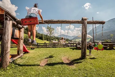 a girl jumping on a swing at a playground at Lüch da Fusse in Badia