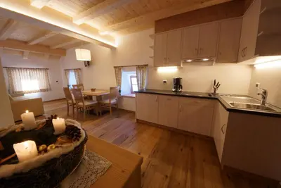 a kitchen and living room with a table and a counter at Lüch da Fusse in Badia