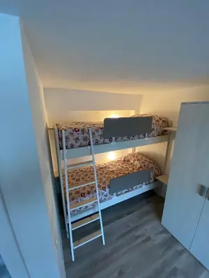a bedroom with a bed and wooden floors at CASA LOLA in Falcade