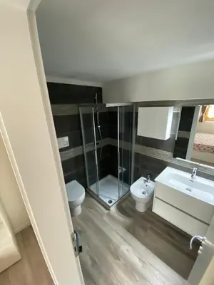 a kitchen and living room with a table and a couch at CASA LOLA in Falcade