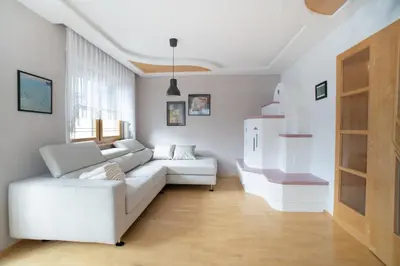 a living room with a white couch and a refrigerator at Landhaus Anita Dolomiten Kronplatz in Perca
