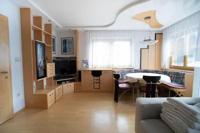 a kitchen and living room with a table and a couch at Landhaus Anita Dolomiten Kronplatz in Perca