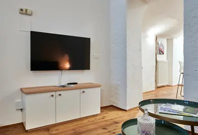a living room with a flat screen tv on a wall at KARINA Lauben Lodge in Egna