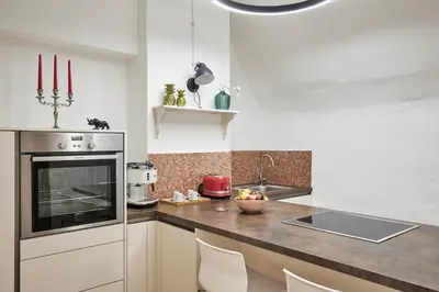 a kitchen with a counter with a sink and a stove at KARINA Lauben Lodge in Egna