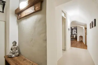 a room with a statue on a bench next to a hallway at KARINA Lauben Lodge in Egna