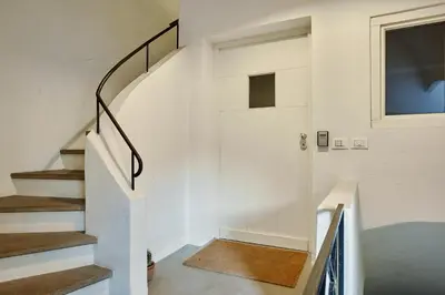 a staircase in a house with white walls and a window at KARINA Lauben Lodge in Egna