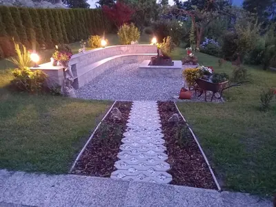 a garden with a stone pathway and a bridge at Waldoase in Schenna