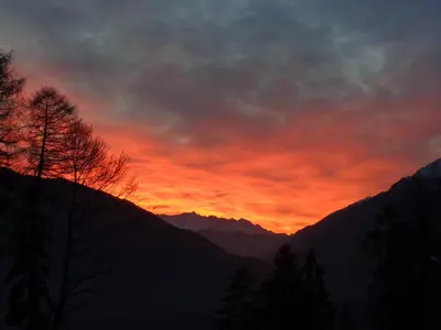 a sunset in the mountains with a red sky at Waldoase in Schenna