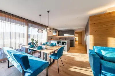 a dining room with a table and blue chairs at Rienz Alpine City Lofts in Brunico