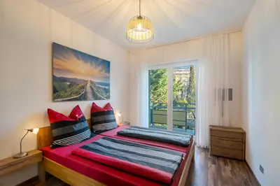 a bedroom with two beds and a large window at Nel cuore di Merano in Merano
