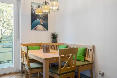 a dining room table and chairs with green cushions at Nel cuore di Merano in Merano