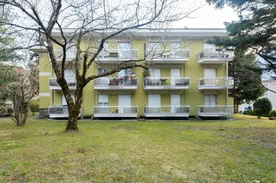 a yellow building with a tree in front of it at Nel cuore di Merano in Merano