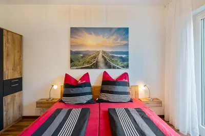 a bedroom with a red bed with red and black pillows at Nel cuore di Merano in Merano