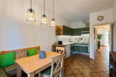 a kitchen with a wooden table and green cabinets at Nel cuore di Merano in Merano