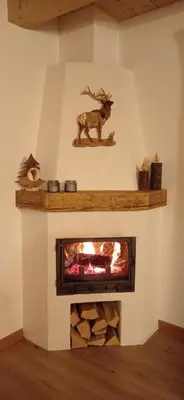 a fireplace with a fake deer on the wall at Tabià sui Prati- Appartamento bilocale in Falcade