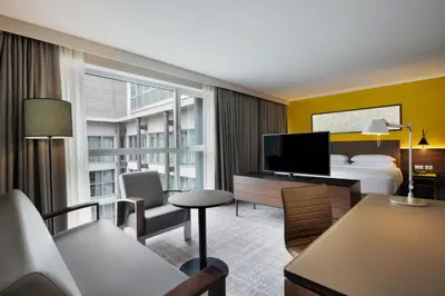 a hotel room with a bed and a television at Four Points Sheraton Bolzano Bozen in Bolzano