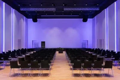a large room with black chairs and a purple wall at Four Points Sheraton Bolzano Bozen in Bolzano