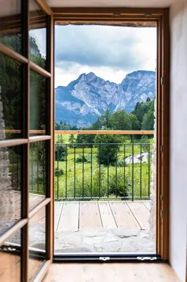 an open door to a balcony with a view of mountains at Bauernhof Hof Unternberg in Magrè allʼ Adige