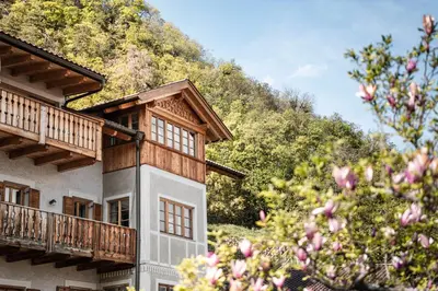 a building with a mountain in the background at Huber unterm Baum in Lagundo
