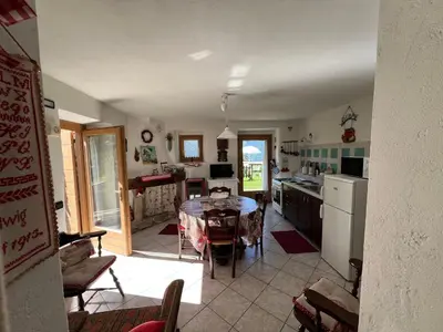 a kitchen and dining room with a table in it at CASA BERNARD Zortea VANOI cuore verde del Trentino in Canale San Bovo