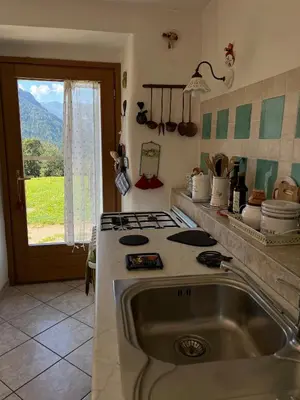 a kitchen with a sink and a stove and a window at CASA BERNARD Zortea VANOI cuore verde del Trentino in Canale San Bovo